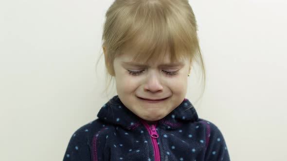 Portrait of Little Child Girl Crying with Tears Down Her Face. White Background