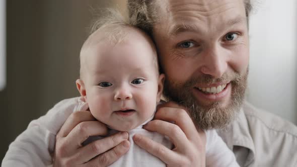 Happy Caucasian Bearded Dad and Cute Infant Newborn Girl Kid Daughter Son Talking to Camera Smiling