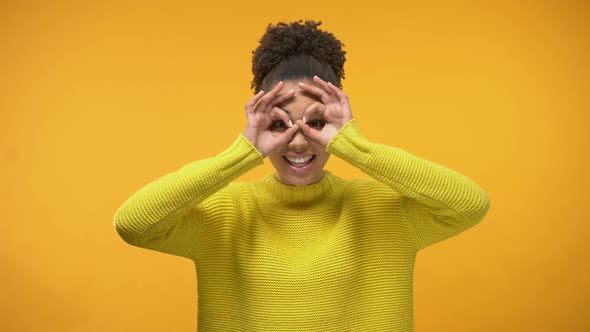 Smiling Black Woman Making Faces, Having Fun, Isolated on Yellow Background