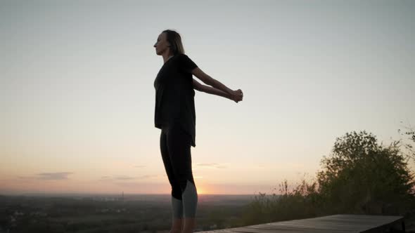 Siluet of Woman Stand on Yoga Mat and Practicing Yoga Stretching Exercise Outdoors in Sunset