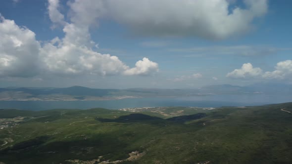 Flying Over of Agricultural Landscape with Many Fields Farmlands Sea and Mountain Background