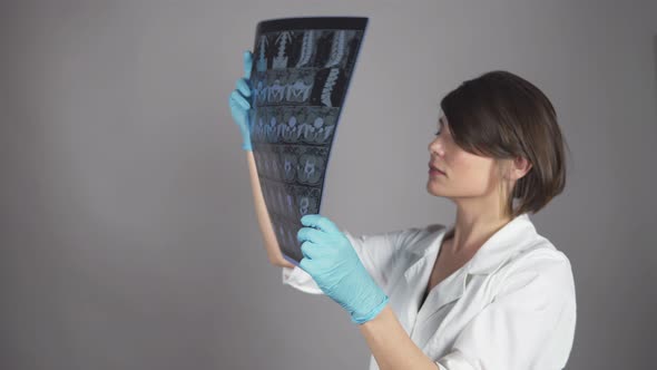 Young Female Nurse Reviewing Xrays Isolated on White Background