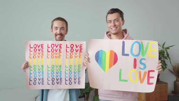 Two Young Handsome Guys Let Down Lgbt Posters Look at Each Other and Smile