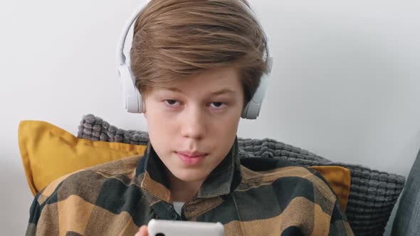 Portrait of a Teenage Boy with a Phone Looking Into the Camera Closeup