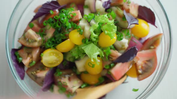 Stirred Vegetable Salad with Wooden Spoons in Glassware