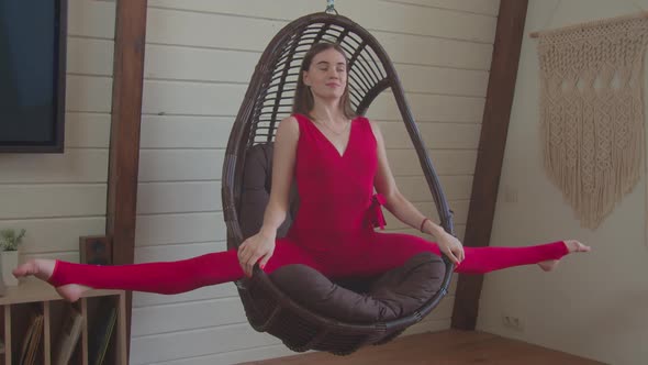 Cute Sporty Fit Woman Doing Splits in Swing Chair