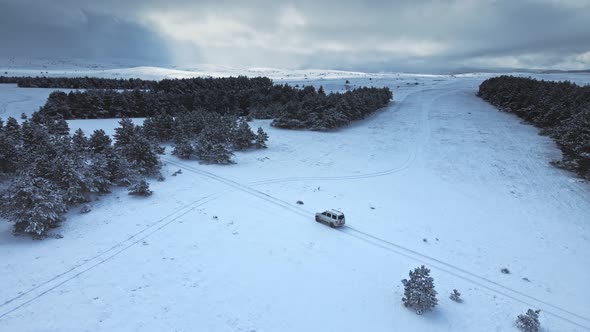 Aerial Drone View of Suv Vehicle Driving on Snowy Ice Road