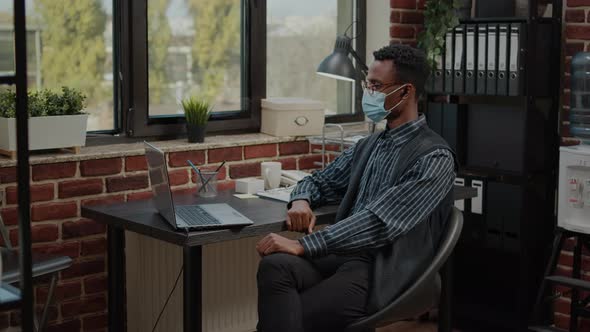 Employee with Face Mask Using Video Call Communication