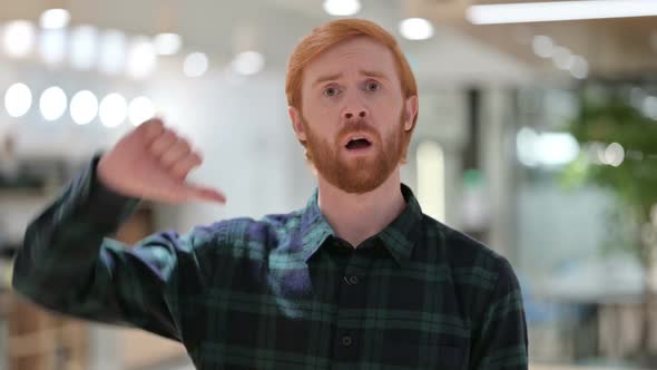 Portrait of Beard Redhead Man with Thumbs Down Gesture