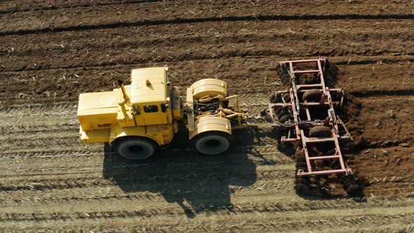 Tractor with Disc Harrows on the Farmland