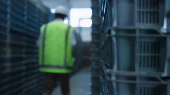 Man Warehouse Employee Walking Among Blue Pallets Analysing Shipment Products