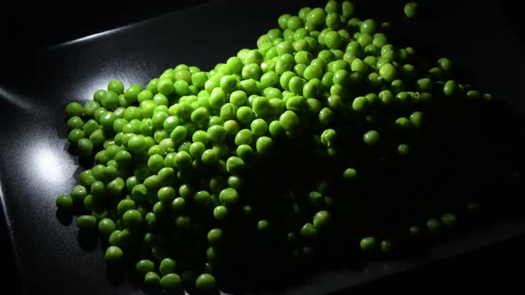 Peas Gyrating on a Black Tray