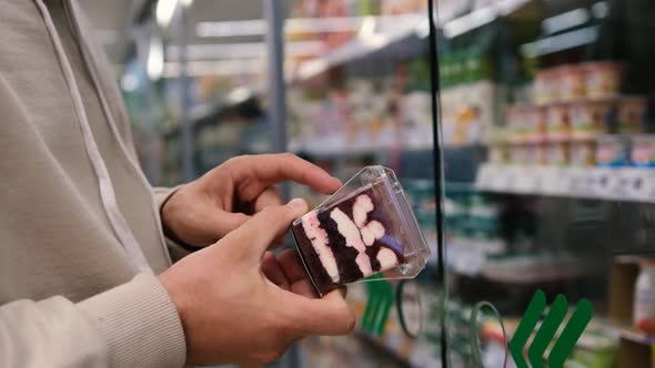 Masked Man Reading Information on Dessert Product While Shopping in Supermarket