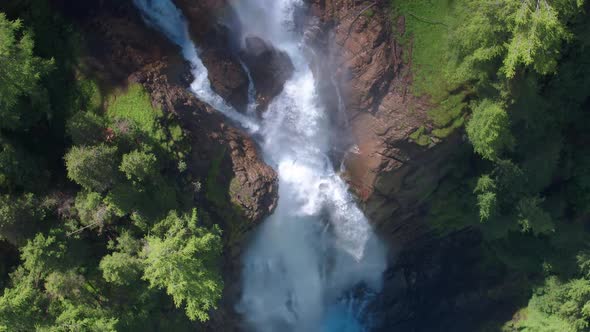 AERIAL LOWERING ZOOM OUT to a dramatic waterfall in Switzerland, Iffigfall