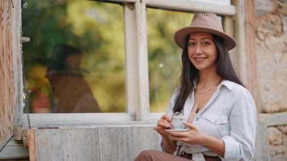 Woman Drinking Coffee Looking at Camera