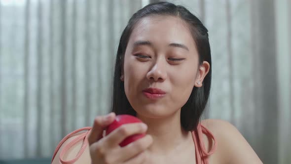 Close Up Of Happy Asian Woman Biting An Apple While Having Healthy Food At Home