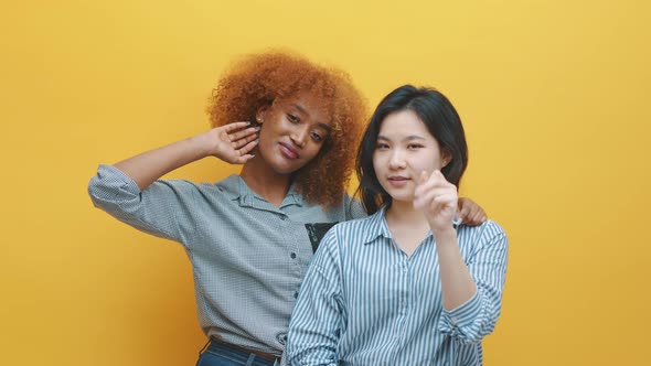 Multiracial Friendship or Lesbian Relationship Concept. African American and Asian Women with Thumbs