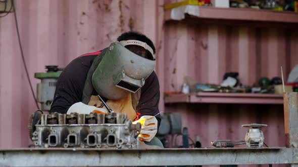 4K Asian man welder working on argon welding machine in construction factory