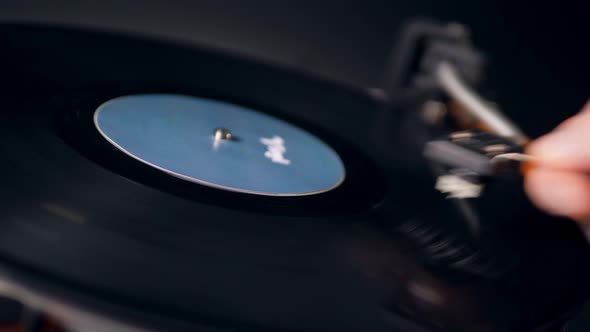 Rotating Vinyl Record and the Cartridge Being Removed From It