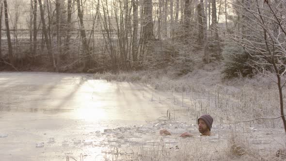 A cyclist rides past L2R as the ice bather sits in freezing cold water, golden light