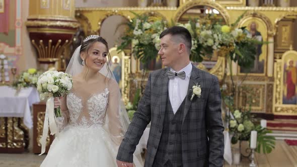 Newlyweds. Elegant Caucasian Bride and Groom Walking Together in an Old Church. Wedding Couple