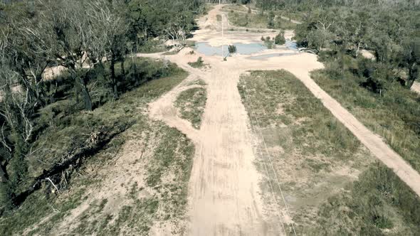 Drone aerial footage of telephone lines on a dirt track in a forest in Australia