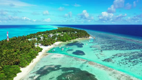 Aerial drone shot sky of marine seashore beach break by turquoise lagoon and clean sandy background 