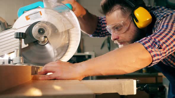 Slow Motion Wood Cutting Held By the Craftsman with a Rotary Saw