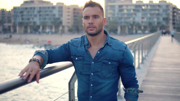 A Young Handsome Man on the Bridge Near Beautiful Beach.