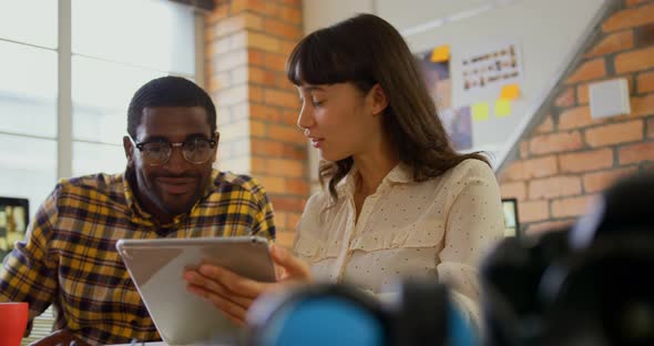 Graphic designers discussing over digital at desk in a modern office 4k