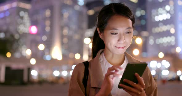 Business woman use of mobile phone in city at night