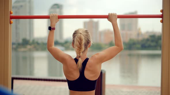 Fitness Sport Street Workout. Muscle Up In Public Gym. Healthy Woman On Pull-up Bars Exercising.