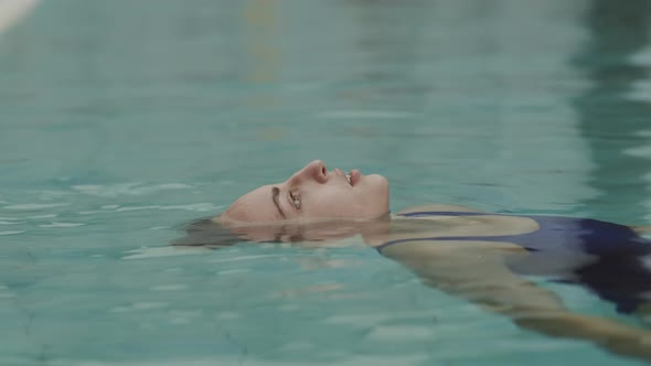 Young Woman Relaxing in Water in Swimming Pool