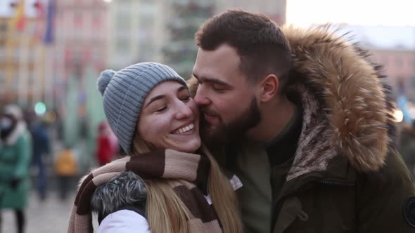 Beautiful couple, boyfriend and girlfriend are kissing on Christmas fair in Wroclaw, Poland