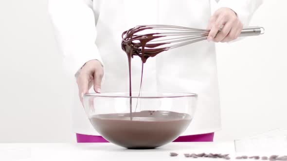 Closeup Chocolatier Pouring Dark Melted Chocolate on White Background, Slow Mo