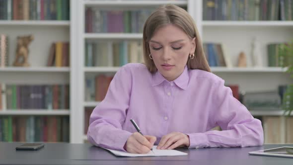 Woman Writing on Paper in Office