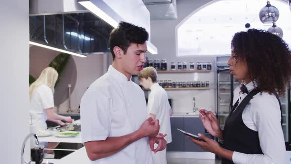 African American female restaurant manager in the kitchen,giving instructions