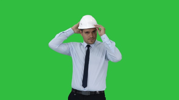 Young construction worker in hard hat on gray background