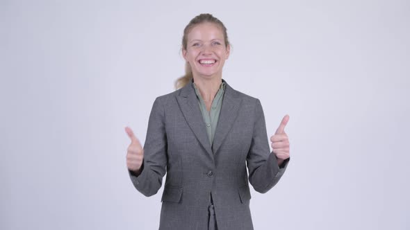 Young Happy Blonde Businesswoman Looking Excited and Giving Thumbs Up