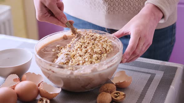 Making Walnut Chocolate Cake  Adding Walnuts to Raw Dough in a Glass Bowl