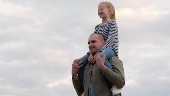 Young Dad Gaily Spending Time with Daughter Playing Together Outdoors on Summer