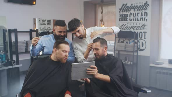 Two Businessmen Chatting Using Tablet Pc Visiting Barber Shop