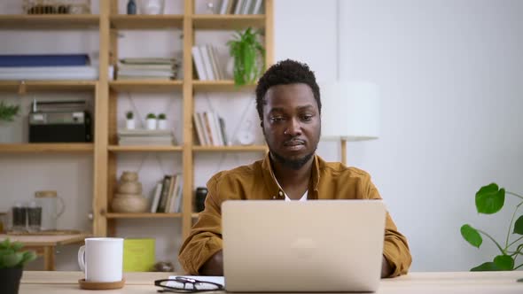 African Man Closes Laptop Lid After Finishing Work on Home Interior Background Spbas