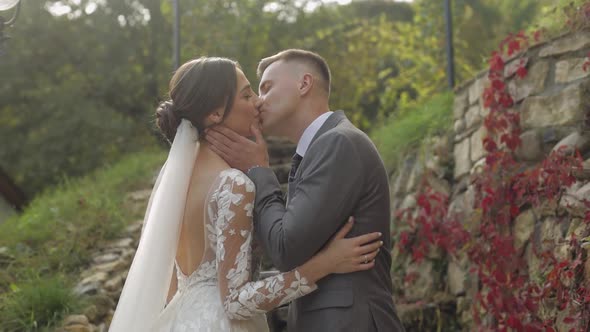 Lovely Newlyweds Caucasian Bride Embracing Groom in Park Making Kiss Wedding Couple Family Hugging