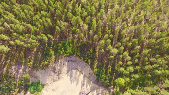 Aerial view of a former gravel pit and harvester tracks in beautiful Finnish coniferous forest. July
