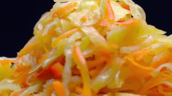 salad of fresh vegetables on a white plate rotates on black background.