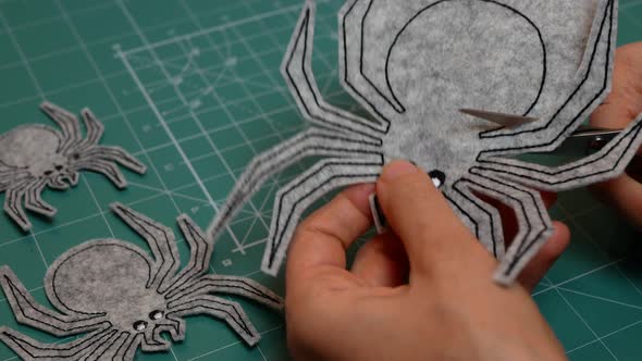 Hands cutting out the silhouette of spider. Holidays and Halloween Decorations