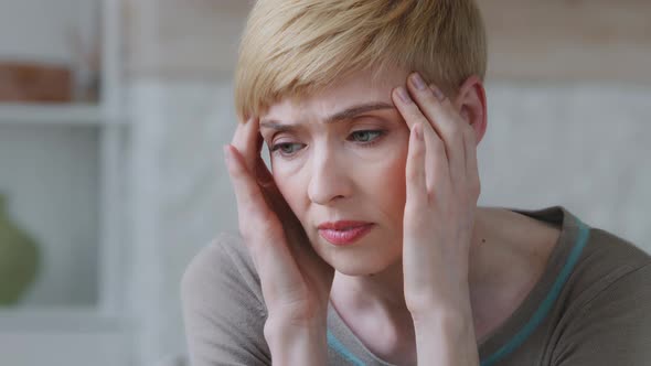 Face of Upset Unhappy Depressed Miserable Woman Rubs Temple Suffers From Tension Headache Painful