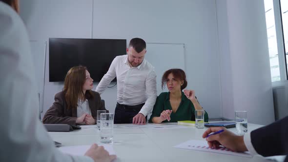 Team Leader Discussing Business Report with Group