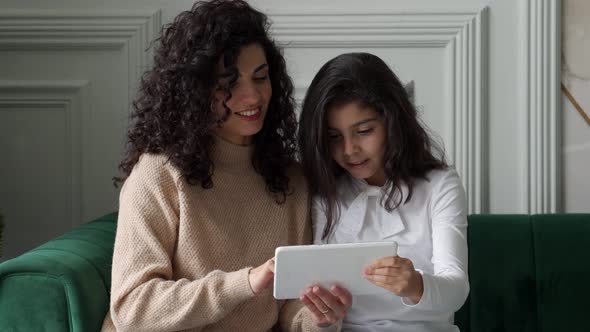 Young Blackhaired Curlyhaired Mother and Daughter Celebrate Success with Digital Tablet Enjoy Being